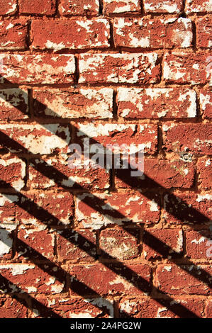 Weathered brick wall and diagonal shadows Stock Photo