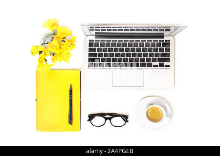 Workspace with laptop computer, fashion glasses, cup of coffee and yellow flower, notebook with pen on white background, isolated. Top view. Flat lay. Concept online shopping. Stock Photo