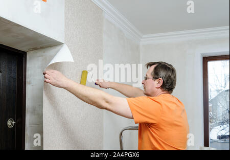 Closeup Photo Of Yellow Wallpaper Roller In Worker's Hand In White