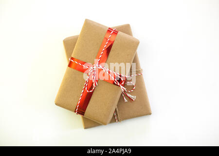 Christmas picture of two gift boxes wrapped with craft paper on white background. Festive minimal xmas concept. Stock Photo