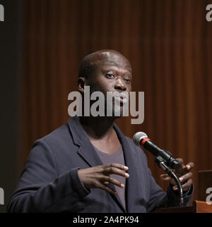 Austin, Texas, USA. 8th Oct, 2019. Noted British architect Sir David Adjaye, a native of Ghana, speaks about his international practice during a lecture at the University of Texas at Austin on October 8, 2019. Adjaye recently was awarded a commission to the build the Abrahamic Family House project in Abu Dhabi. Credit: Bob Daemmrich/ZUMA Wire/Alamy Live News Stock Photo