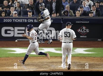 Bronx, United States. 15th Oct, 2019. Houston Astros Jose Altuve scores when New York Yankees Zack Britton throws a wild pitch in the 7th inning in game 3 of the American League Championship Series at Yankee Stadium on Tuesday, October 15, 2019 in New York City. The Yankees and the Astros are tied in the best of 7 series 1-1. Photo by John Angelillo/UPI Credit: UPI/Alamy Live News Stock Photo