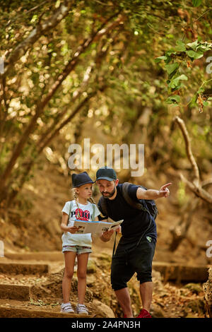family dad and little cute daughter hiking in a forest Stock Photo