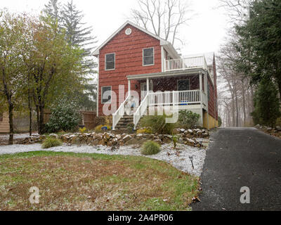 first snow of the season in November on red suburban house in the East Coast USA Stock Photo