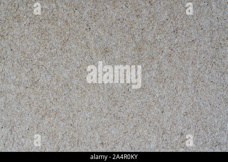 Light brown background from sheet of recycled cardboard. Close-up detail view of abstract texture recycled eco-friendly material pattern background. Stock Photo