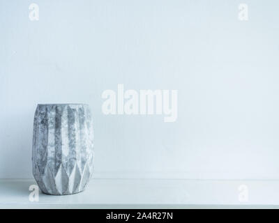 Concrete pot. Empty modern geometric concrete planter on wooden shelf isolated on white background with copy space. Stock Photo