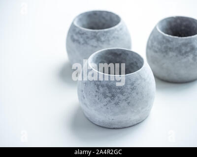 Concrete pots. Close-up empty three modern round concrete planters isolated on white background. Stock Photo
