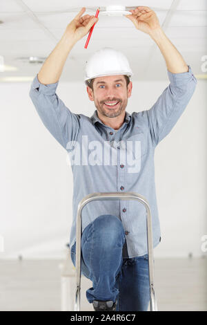 a technician works on ceiling Stock Photo