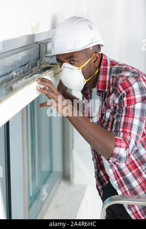 worker spraying pesticide on window corner Stock Photo