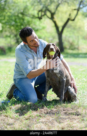 man plays with a dog outdoor Stock Photo