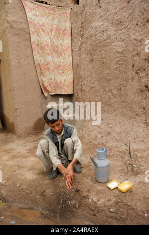 A boy washes his hands with soap after using a low cost sanitary latrine, in the village of Khwaja Surmaq, in Anjil district, Herat province, Afghanistan. May 7, 2009. The sanitary latrine is a contribution of Neda-e-Zan, an NGO that runs water and sanitation initiatives in the village. Stock Photo