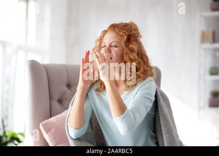 Young woman sneezing all day long after catching cold