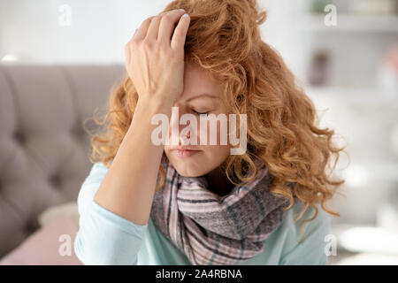 Curly young woman wearing scarf feeling sick and tired Stock Photo