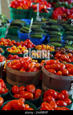 Biologic, natural cultivated tomatoes on a market counter. Vegetables from the farmers market. Ecologic products. Natural background. Stock Photo