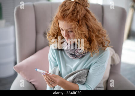 Woman feeling sad after measuring body temperature Stock Photo