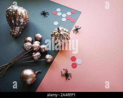 Creative paper craft Halloween flat lay with copy-space. Pink and grey split paper background with black spiders and paper hexagons. Stock Photo