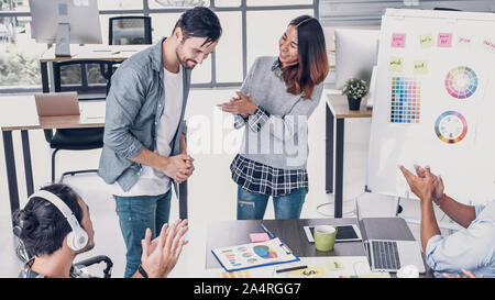 Female creative director boss announce to designer and congratulation about getting promotion of job in modern creative office Stock Photo
