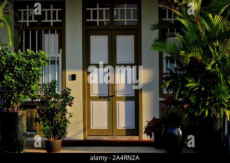 Entrance to traditional Singapore shop house in historic Joo Chiat in soft morning light with decorative plants Stock Photo