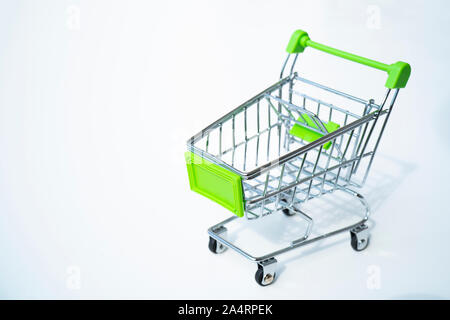 Empty green miniature shopping cart isolated on white background. Stock Photo