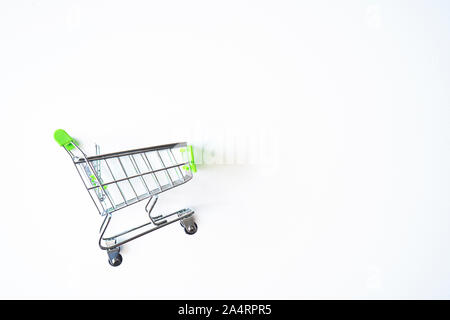 Empty green miniature shopping cart isolated on white background. Stock Photo