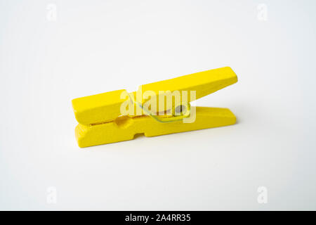Yellow wooden clothespins on a white background. Stock Photo