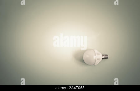 Electric energy-saving lamp on a light background. Stock Photo