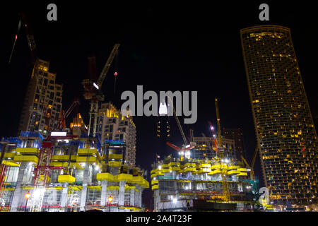 Construction of a large city building at night. Stock Photo
