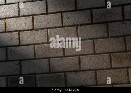 Lighted decorative beige brickwork as a closeup background. Stock Photo