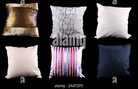 A set of square cushions made from different designs and material, on black studio background. Stock Photo