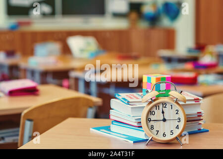 The students took a break. Empty classroom and alarm clock. Background with copy space. Stock Photo