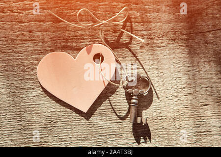 Vintage key and pink heart on a string with a bow. Valentine. Space for text. Close-up, top view. Stock Photo