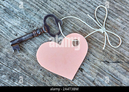 Vintage key and pink heart on a string with a bow. Valentine. Space for text. Close-up, top view. Stock Photo