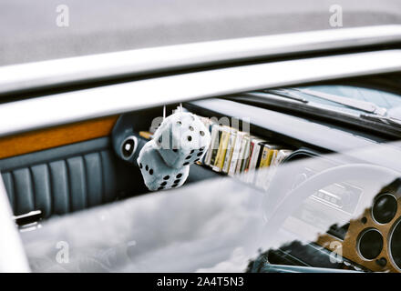White furry fluffy dice hanging in classic car, Nottingham Transport Festival, Autokarna 2019, Wollaton Park, east Midlands, England Stock Photo