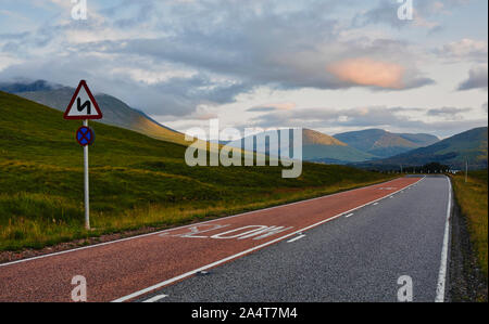 Winding road ahead sign on road through the majestic Scottish Highlands, Scotland