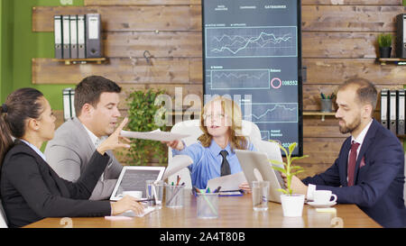 Female manager presents new project plan to colleagues at meeting in the conference room. Stock Photo