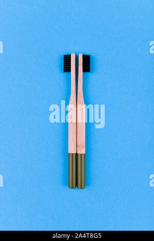 wooden toothbrush on a blue background. Close up wooden toothbrush on a blue background. eco brush. Stock Photo
