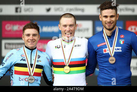 Australia's Rohan Dennis (centre) celebrates on the podium after winning gold alongside silver medallist Belgium's Remco Evenepoel (left) and bronze medallist Italy's Filippo Ganna during the Men's Elite Individual Time Trials from Northallerton to Harrogate. Stock Photo