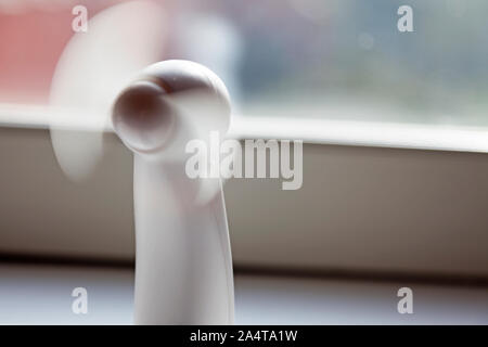 heat wave at work, we take out the table fan and put it in the window Stock Photo