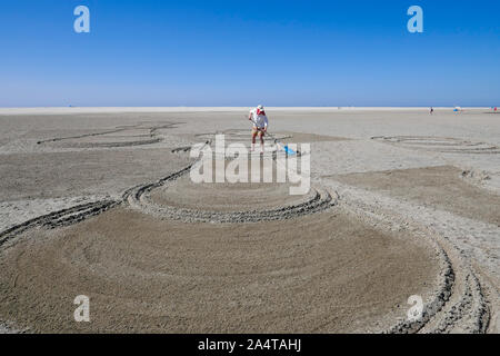 Creating sand drawings at beach in Holland Stock Photo