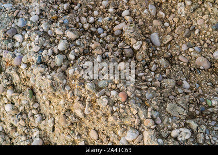 Small sea pebbles on the sand of the beach Stock Photo
