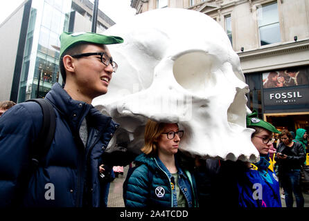 London October 12th 2019  Extinction Rebellion Funeral March from Marble Arch. Protesters in the procession carry a giant skull past a shop called Fos Stock Photo