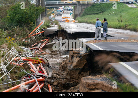 Mito City, Japan. 15th Oct, 2019. Local residents walk on a collapsed road following the Typhoon Hagibis.The death toll rises to 48, two days after Typhoon Hagibis passed through Japan while 15 are still missing and more than 100 injured as thousands of troops are deployed on rescue missions across the country. Credit: SOPA Images Limited/Alamy Live News Stock Photo