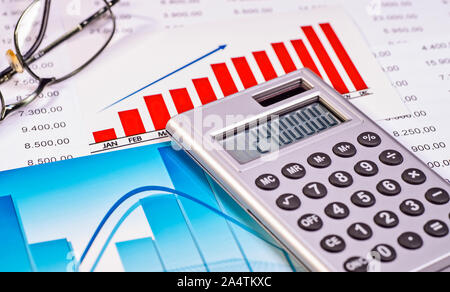 Diagrams and tables with calculator and glasses Stock Photo