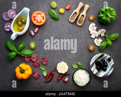 The ingredients for homemade pizza on dark stone background. Stock Photo