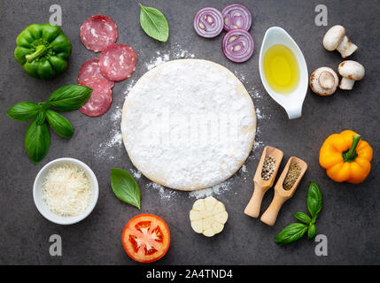 The ingredients for homemade pizza on dark stone background. Stock Photo