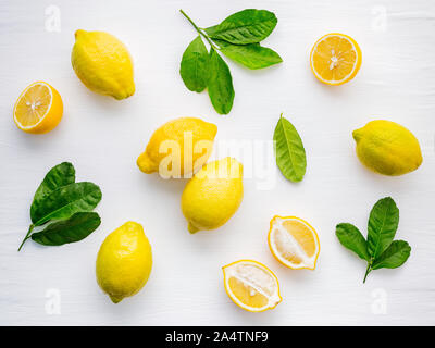 Fresh lemons and  lemons leaves on white wooden background. Stock Photo