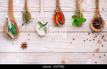 Various of spices and herbs in wooden spoons. Flat lay spices ingredients chili ,peppercorn, rosemarry, thyme,star anise ,sage leaves and sweet basil Stock Photo