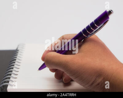 Hand holding pen , Businessman making notes on the paper. Stock Photo