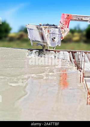 Distribution of concrete for the realization of the floor of a house under construction. Stock Photo