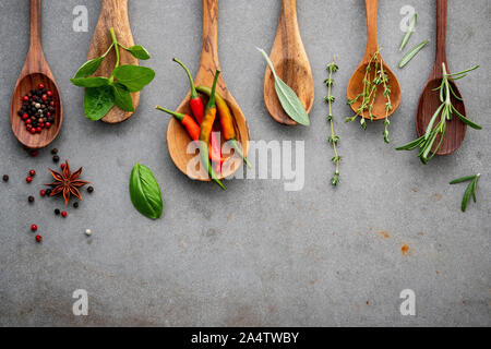 Various of spices and herbs in wooden spoons. Flat lay spices ingredients chili ,peppercorn, rosemarry, thyme,star anise ,sage leaves and sweet basil Stock Photo